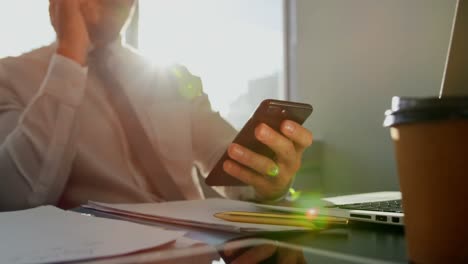 front view of young caucasian male executive working on mobile phone at desk in modern office 4k