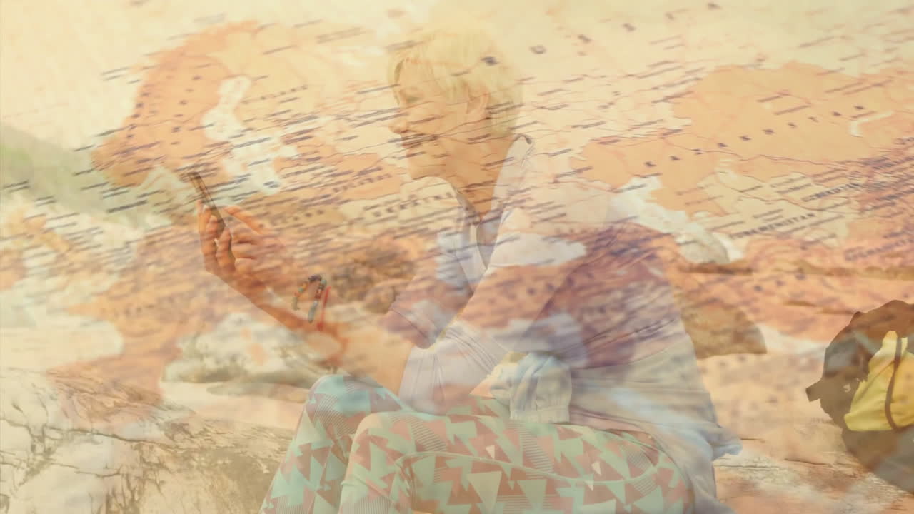 Mature woman holding smartphone on rocky shore, showing travel tech Europe-Atlantic map overlay