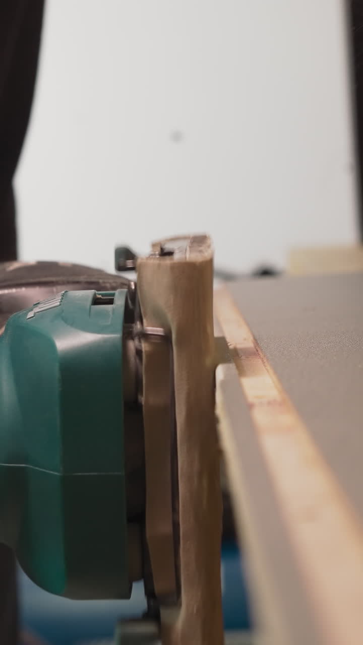 Worker grinds wooden workpiece edge with electrical tool in workshop closeup. Man making handmade furniture at plant. Handwork in carpentry shop