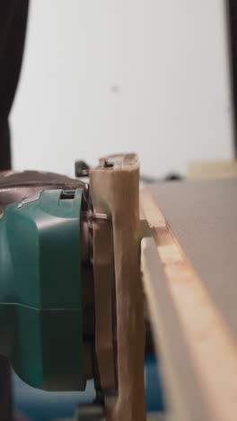 worker grinds wooden workpiece edge with electrical tool in workshop closeup. man making handmade furniture at plant. handwork in carpentry shop