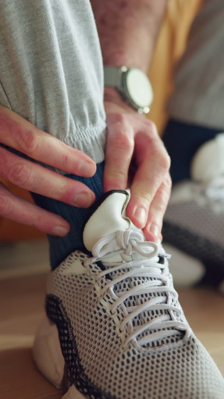 Primo piano di una persona che indossa una scarpa sportiva e si sistema il calzino