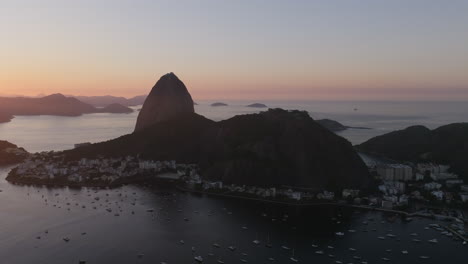 aerial footage slowly moving towards the silhouette of sugarloaf mountain during the sunrise in rio de janeiro brazil