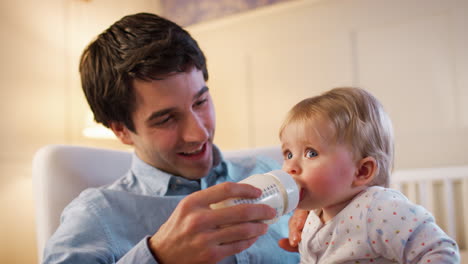 Vater-Im-Kindergarten-Füttert-Seine-Kleine-Tochter-Aus-Der-Flasche