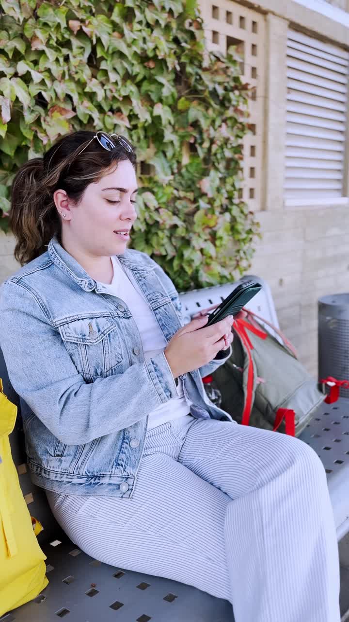 A Young Traveler Engrossed in Her Smartphone at a train station platform