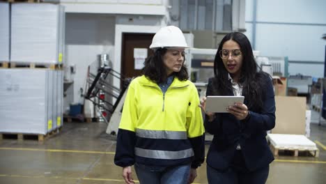 Zwei-Arbeiterinnen-Gehen-Mit-Tablet-In-Der-Fabrik