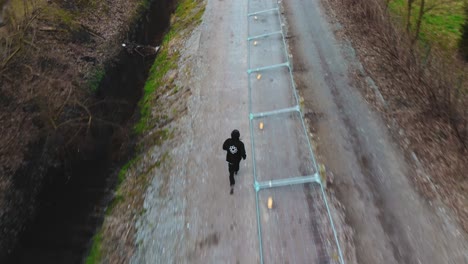 aerial chasing man running through forest looking for freedom