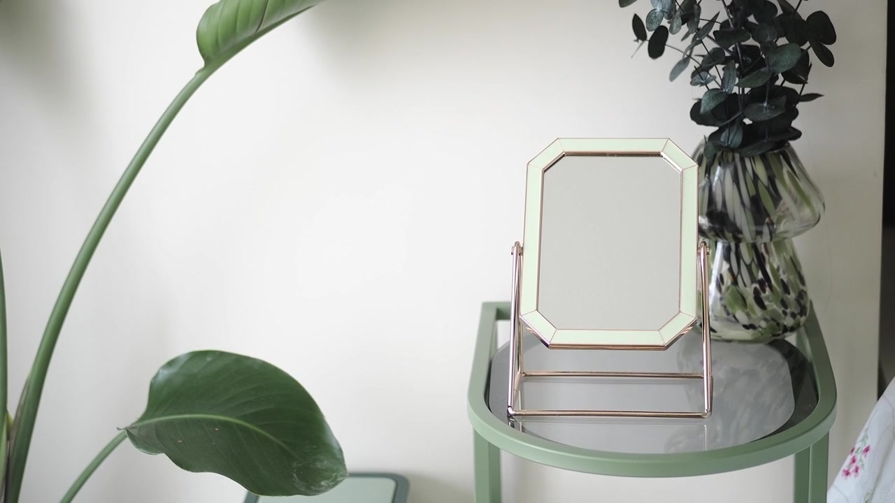 Piccolo specchio decorativo su un tavolino verde in una camera da letto