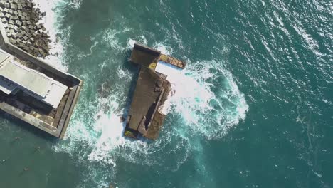 vista aérea de la destrucción de las olas en el puerto deportivo desactivado de lugar de baixo, ponta do sol, isla de madeira, portugal