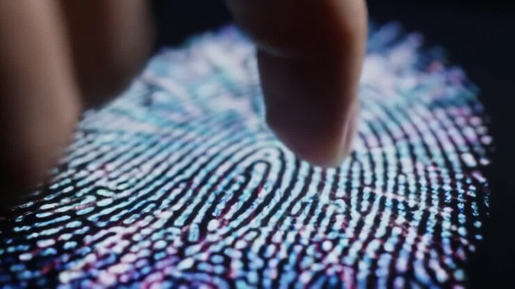 A close-up view shows a finger touching a digital fingerprint sensor that captures unique patterns for identification. This technology plays a key role in security and law enforcement.
