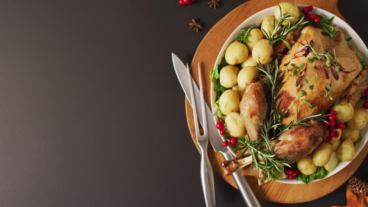 video de una bandeja con pavo asado, patatas y cubiertos en superficie gris