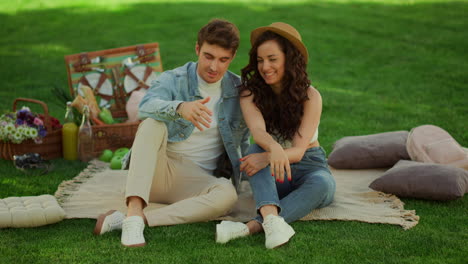 sweet couple speaking on picnic. calm girl and guy talking in park