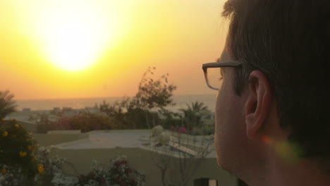 Man-putting-on-glasses-and-enjoying-nature-scene