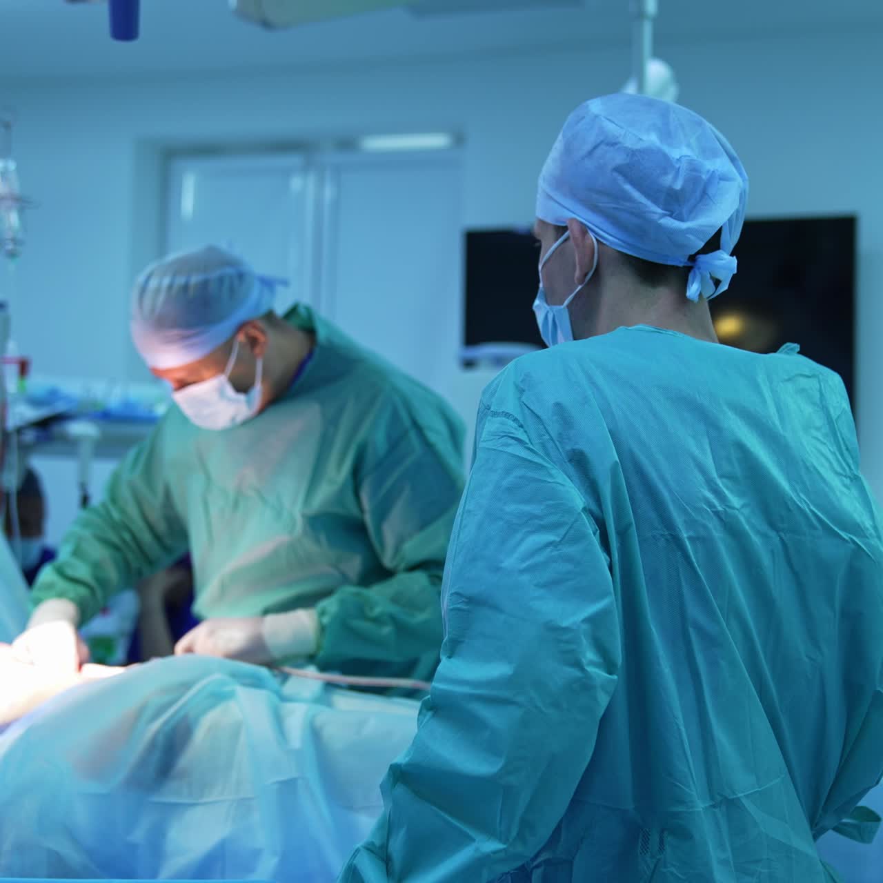 Abdominal liposuction. Professional surgeon together with male assistant perform a surgery on a patient's tummy for fat removal
