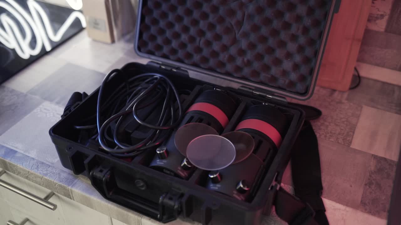 주방 카운터 에 검은색 하드 케이스 를 열고 있는 사람