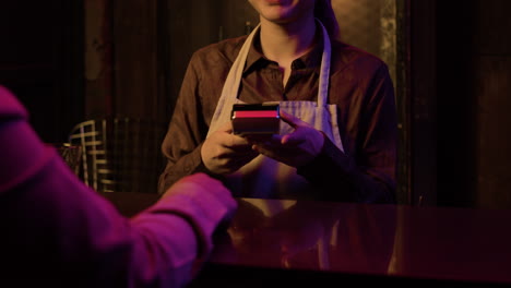 hombre pagando por una bebida en el bar