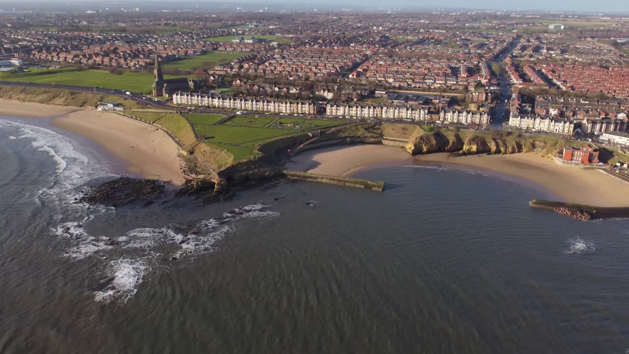 Aerial view overlooking Cullercoats beach and Tynemouth Longsands with relaxing morning waves