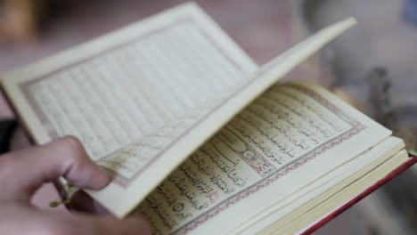 man turns page in book written in arabic in mosque cairo egypt, slow motion