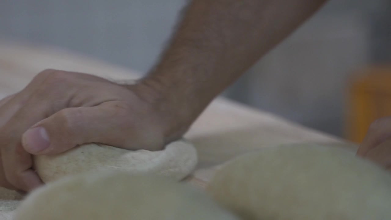 Panettiere che impasta a mano