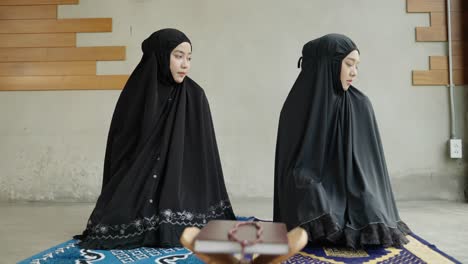 two young muslim women are performing prayers. islamic religion,part 2