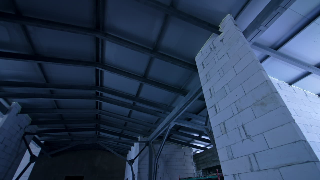 Newly constructed roof of the large building. Low angle view. Metal bulks and brick bulkheads holding the roof.
