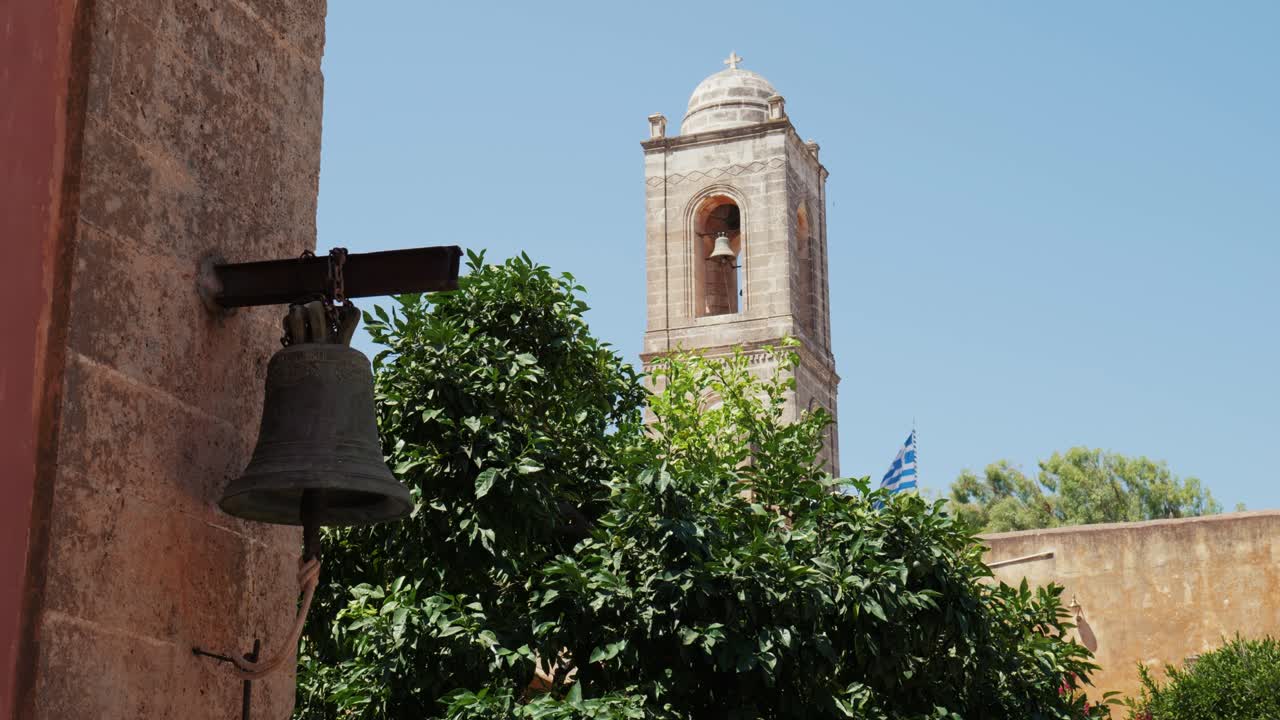 focus shift of medieval Mediterranean building with greek flag in ancient Orthodox monastery Agia Triada, Crete Greece