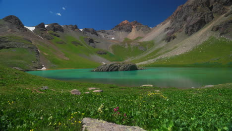 la cuenca del lago de hielo de colorado el comienzo del sendero más bajo increíble azul brillante alpino agua clara verano flores silvestres cielo azul cordillera rocosa nevada picos silverton telluride soñador pacífico lento pan izquierda movimiento