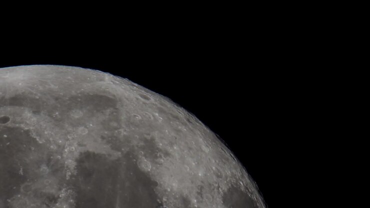 Um vídeo super telefoto da Lua Cheia gigante passando pelo céu noturno no espaço, filmado com um telescópio