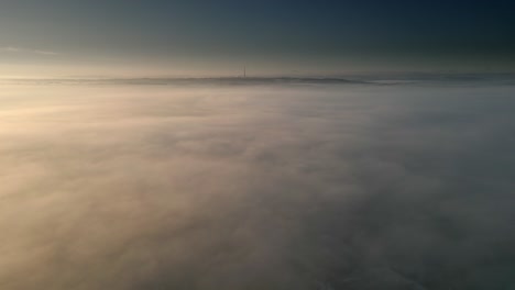 aerial drone scene above the urban townscape areas shrouded in thick morning mist