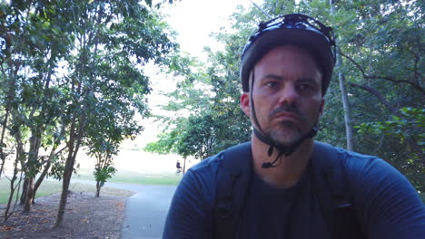 man riding a bike on a footpath in slow motion close up on face