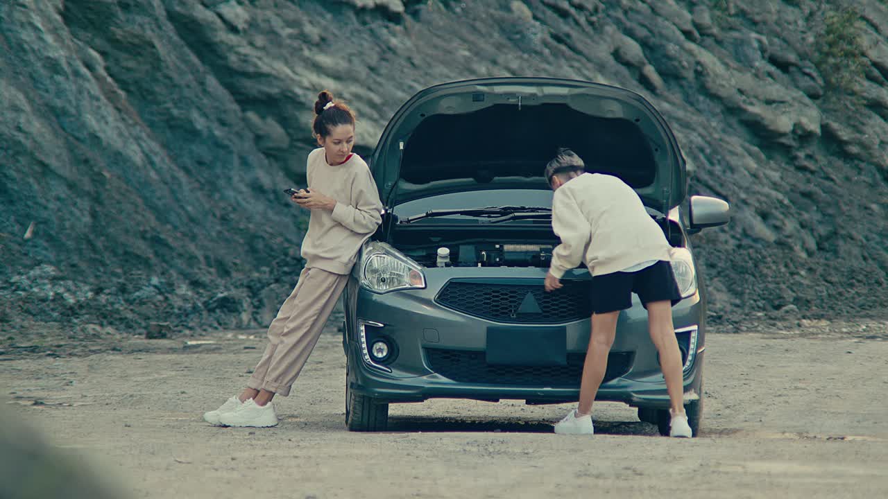 Women Trying to Fix a Broken Down Car
