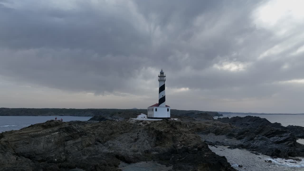 A zoomed-out view of the Fav&agrave;ritx Lighthouse on a cloudy day, Menorca