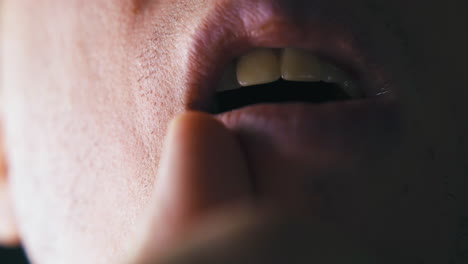 shaved man with opened mouth holds finger on lip corner