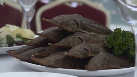 smoked sterlet put on a plate slow motion