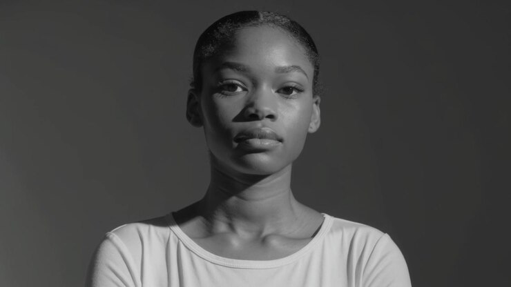 Camera starting, woman posing, shifting, blinking in dark backdrop crewneck for portrait