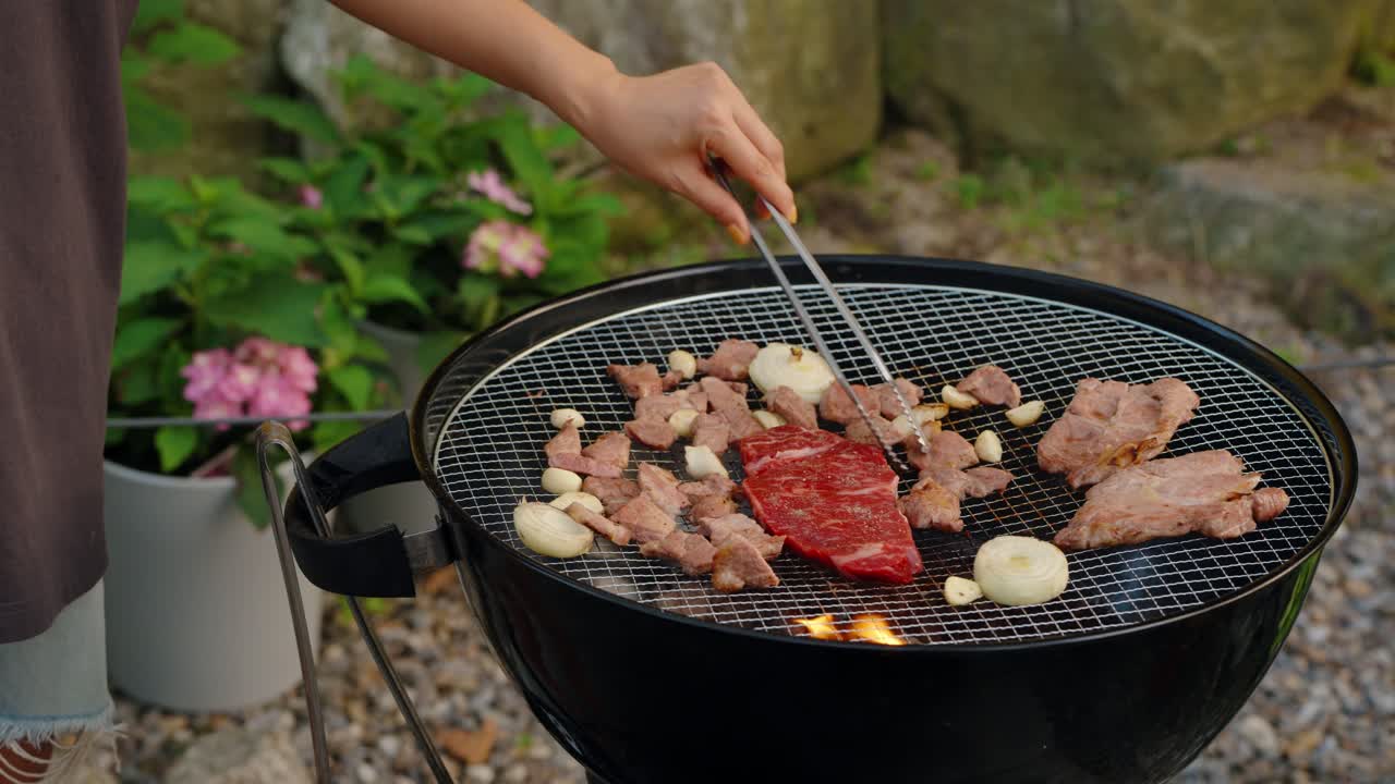 A woman cooking a Korean-style barbecue in a beautiful garden setting