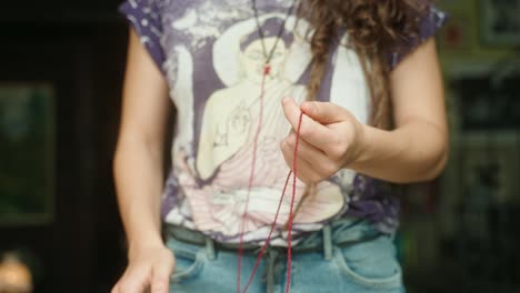 Person-following-red-string-closeup-of-hands