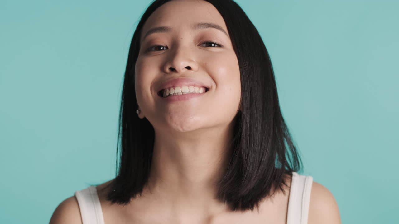 카메라에 이빨을 보여주는 아시아 여성.