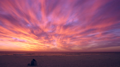 sunset at the beach with a person watching