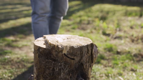 Close-up-view-of-caucasian-man-chopping-firewood-with-an-ax-outside-a-country-house.-Then-he-looks-at-camera