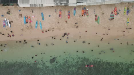 Overhead-drone-shot-of-white-sandy-coastline-with-crowded-of-visitors-during-summer-holidays