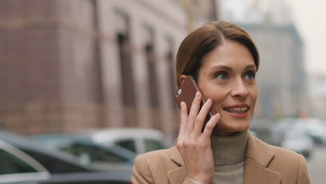 Close-up-view-of-caucasian-charming-businesswoman-in-elegant-clothes-walking-on-the-street-and-talking-on-the-phone