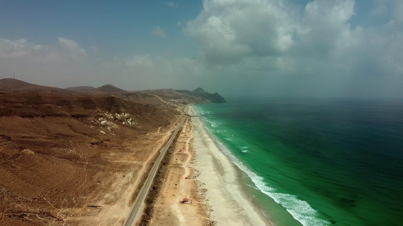 Vista aerea mozzafiato di Mughsail Beach, Oman! Sabbie bianche incontrano acque turchesi e scogliere imponenti. Guarda ora!