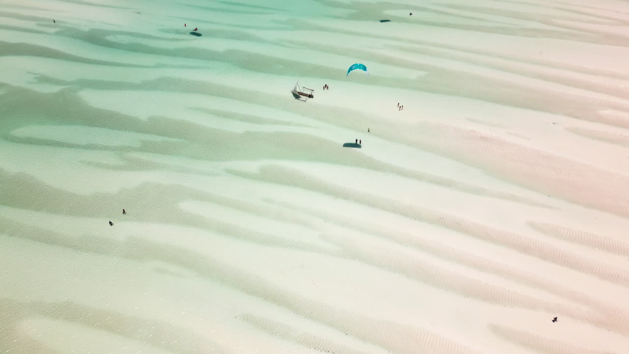Aerial view of sandbanks and kite surfers in shallow waters