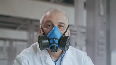 Retrato-De-Un-Médico-Con-Traje-Protector-Durante-La-Pandemia-Del-Coronavirus.-Médico-Masculino-Con-Traje-De-Peligro,-Guantes-Y-Gafas-Con-Máscara-Respiratoria,-Preparándose-Para-El-Día-De-Trabajo-En-La-Clínica-U-Hospital.-Protección-Contra-El-Concepto-Epidémico-De-Coronavirus-Covid-19