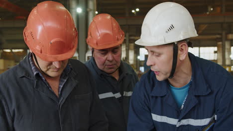 trabajadores de la fábrica inspeccionando el equipo