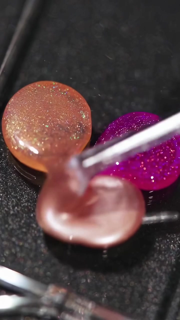Primer plano de brochas de maquillaje mezclándose en sombras de ojos brillantes