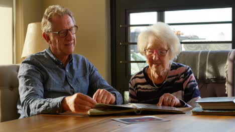 active senior couple looking at photo album 4k