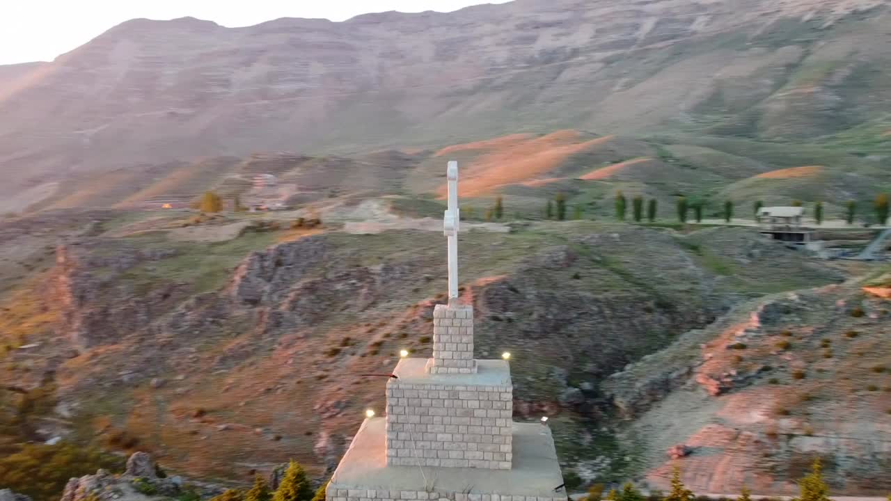 Aerial View of Cross on Mountain at Sunset