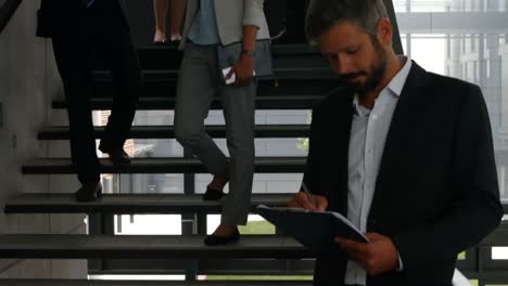 businessman writing on clipboard