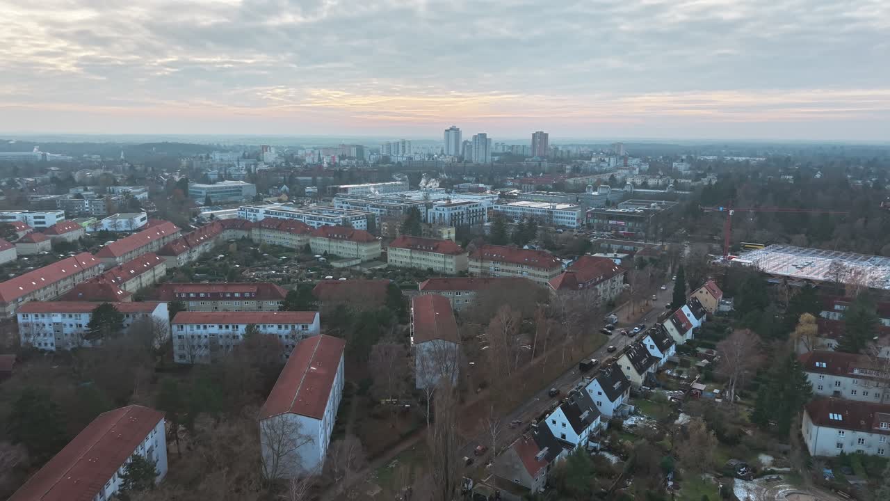 Aerial view of Berlin cityscape featuring residential buildings and distant skyscrapers under a cloudy sky in Germany
